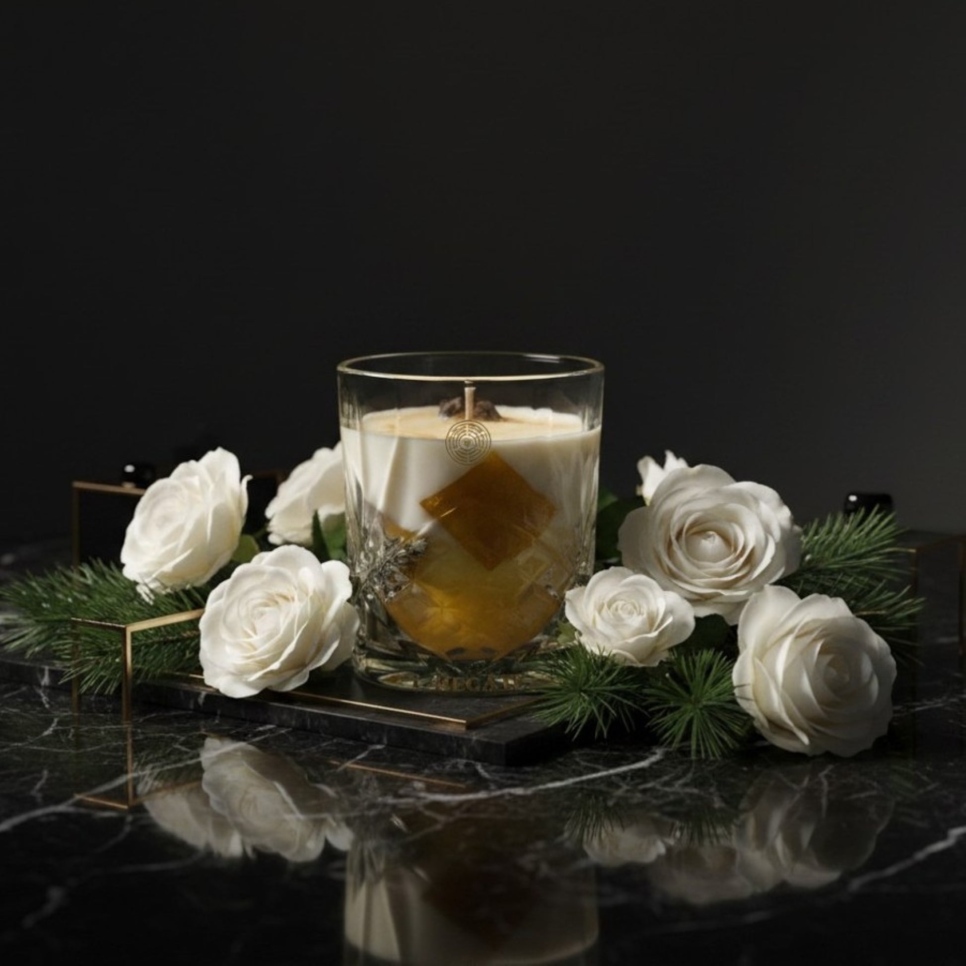 Glass candle with a white flower arrangement on a dark surface